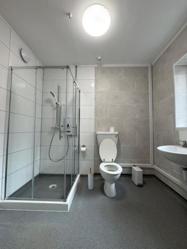 Un baño con ducha, inodoro y lavabo. en Serenity Rooms, en Leicester