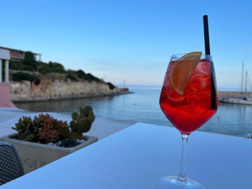 una copa de vino en una mesa con vistas al océano en La casetta di Iaia - Tricase, en Tricase