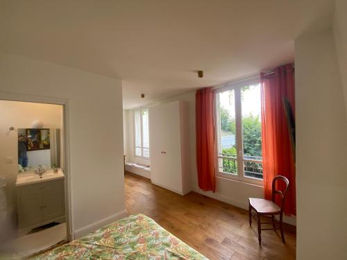 a room with a bathroom with a sink and a window at Grande maison de charme in Enghien-les-Bains