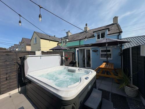 a hot tub on the back yard of a house at Pauls Place in Brynsiencyn