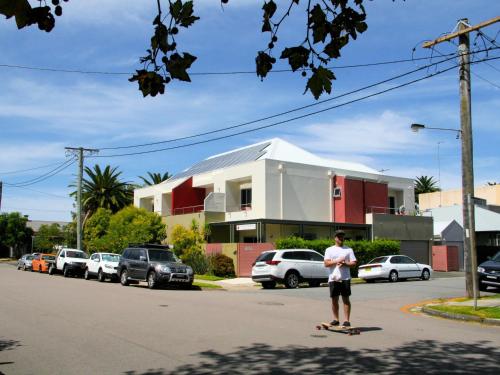 a man riding a skateboard down a street at Chaucer Palms Boutique B&B in Newcastle