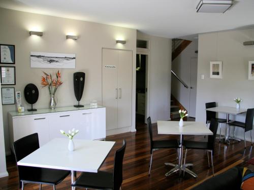a dining room with two tables and chairs at Chaucer Palms Boutique B&B in Newcastle