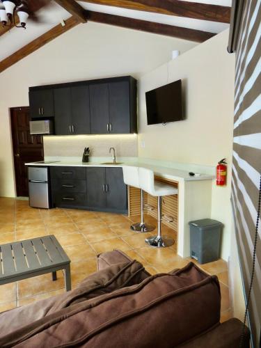 a kitchen with a table and a kitchen with black cabinets at Beachy Studio Hideaway Steps to Sand & Sunset in Playa Flamingo