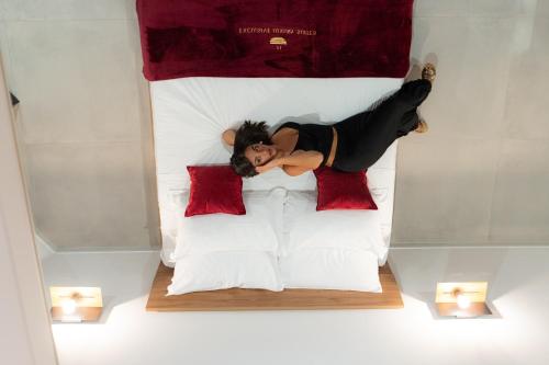 a woman laying on top of a bed at 5 Stars - Exclusive Luxury Suites with a jacuzzi in Trapani
