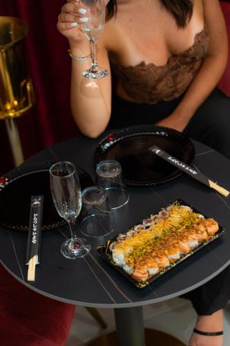 a woman sitting at a table with a plate of food at 5 Stars - Exclusive Luxury Suites with a jacuzzi in Trapani