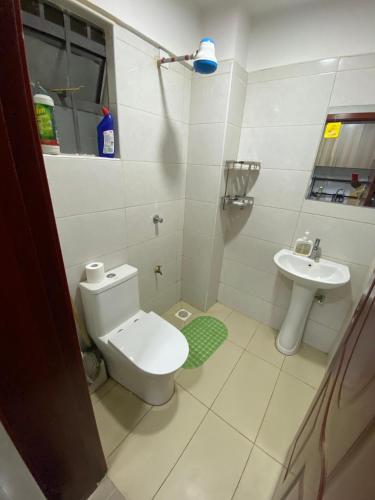 een kleine badkamer met toilet en wastafel bij Haven 254 Stade view Suites in Nairobi