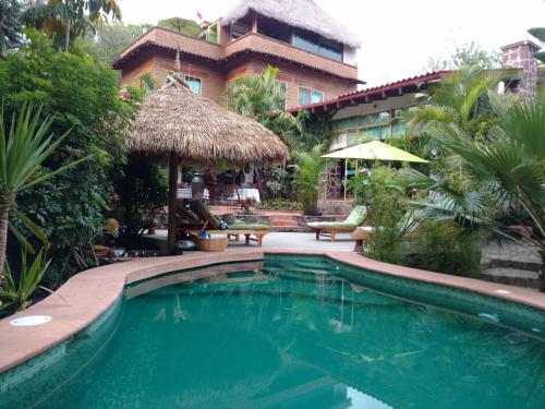 a swimming pool in front of a building with a resort at Casa d'Lobo Hotel Boutique in Malinalco