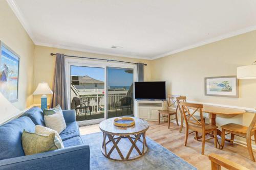 a living room with a couch and a table and a dining room at Oceanfront Retreat 318 Breakers in Hilton Head Island