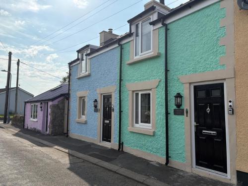 a row of colorful houses on a street at Pauls Place in Brynsiencyn
