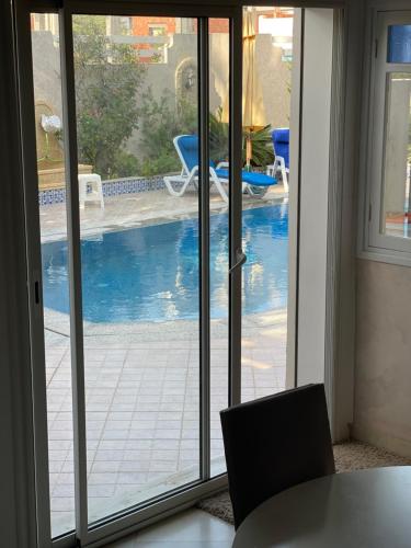 a sliding glass door with a view of a swimming pool at La Villa Bleue Djerba Houmt Souk in Houmt Souk