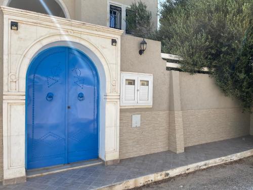 a blue door on the side of a building at La Villa Bleue Djerba Houmt Souk in Houmt Souk