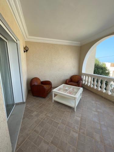 a living room with leather chairs and a table at La Villa Bleue Djerba Houmt Souk in Houmt Souk