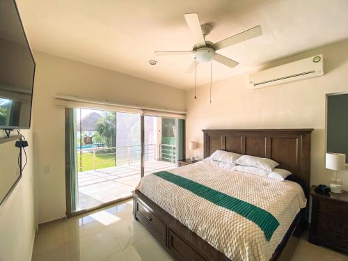 ein Schlafzimmer mit einem Bett und einem Deckenventilator in der Unterkunft Casa Santorini in Cozumel