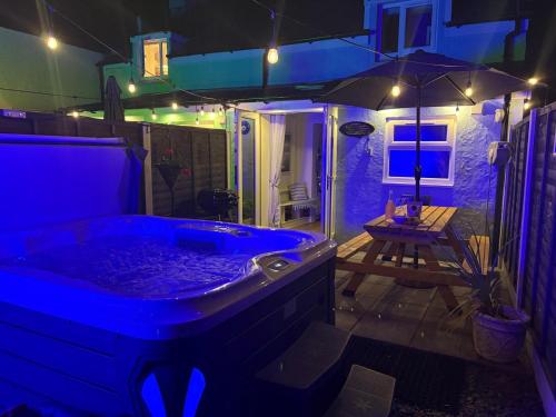a jacuzzi tub in a backyard at night at Pauls Place in Brynsiencyn