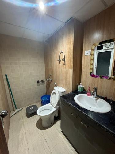 a bathroom with a toilet and a sink at Complete Comfort Suite - Pool, WiFi & Caring Hosts in Noida