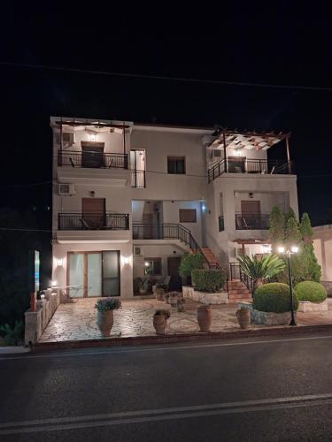 a large white building at night with lights at Kandania Apartments in Kántanos