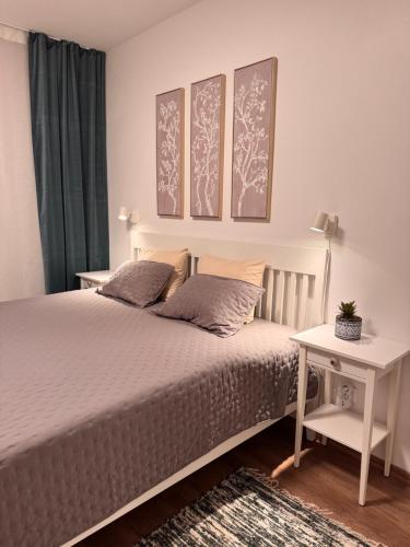 ein Schlafzimmer mit einem Bett mit zwei Kissen und einem Tisch in der Unterkunft Apt 555 New & Fully Equipped with Free Garage in Bratislava