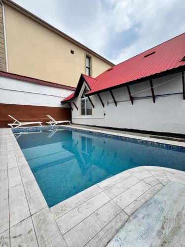 una piscina di fronte a un edificio con il tetto rosso di Gabala A frame a Gabala