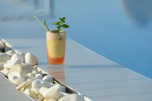 a glass table with a vase with a plant in it at The Noverian Scenic Crete 5 Star Hilltop Villa Resort & Spa in Malia