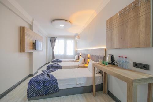 a room with two beds and a desk in it at Kar Hotel in Mersin