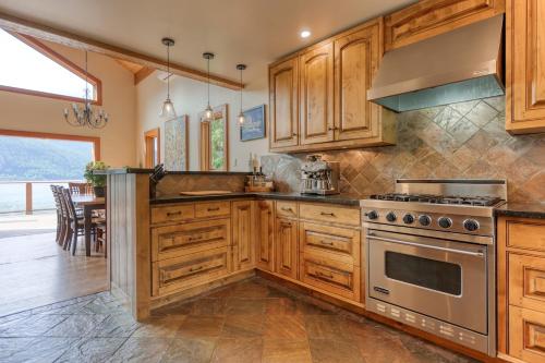 a kitchen with wooden cabinets and a stove at Custom Built Home on the Beach in Nelson