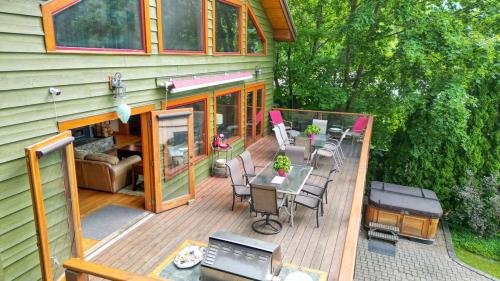 a house with a deck with a table and chairs at Custom Built Home on the Beach in Nelson
