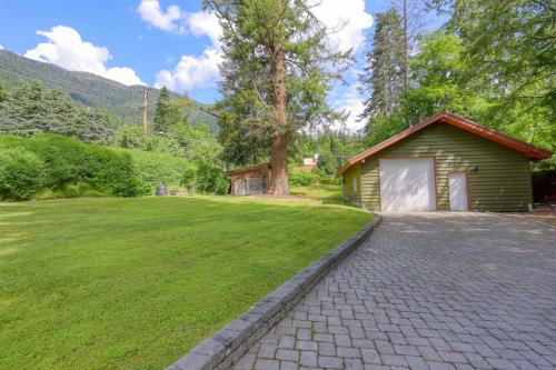 a small green building with a large grass yard at Custom Built Home on the Beach in Nelson