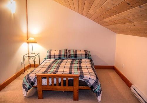 a bedroom with a bed with a wooden ceiling at Custom Built Home on the Beach in Nelson