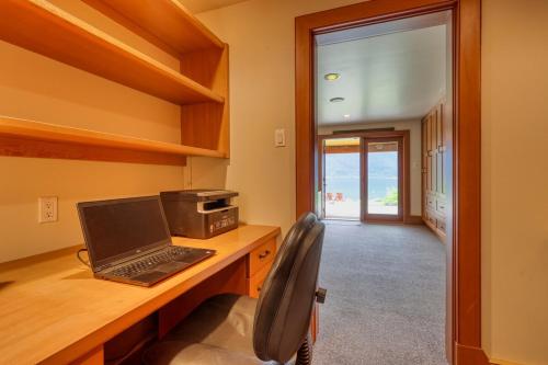 a laptop computer sitting on a wooden desk in a room at Custom Built Home on the Beach in Nelson