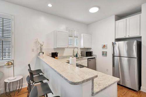 a kitchen with white cabinets and a stainless steel refrigerator at Retreat on Spring, Unit B in Charleston