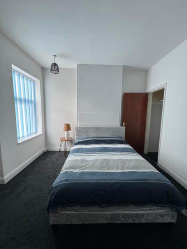 a bedroom with a large bed and a window at Serenity Rooms in Leicester