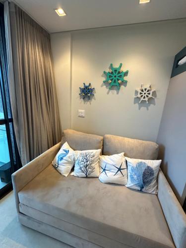 - un salon avec un canapé et quatre oreillers dans l'établissement Flat no Paraíso da praia do Cupe - Porto de Galinhas, à Porto de Galinhas