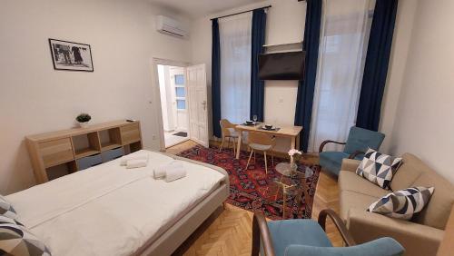 a small room with a bed and a couch and a table at City Park Home in Budapest