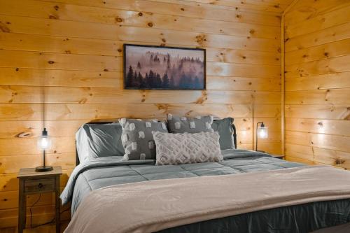 ein Schlafzimmer mit einem Bett in einer Holzwand in der Unterkunft Relaxing cabin retreat-pool, hot tub and game room in Sevierville