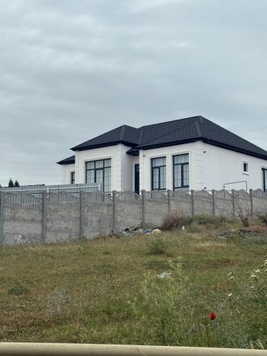 a white house with a fence in front of it at Melhem Twin Homes in Şamaxı
