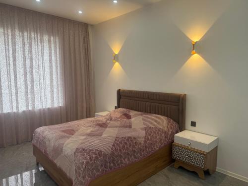a bedroom with a bed and two lights on the wall at Melhem Twin Homes in Şamaxı
