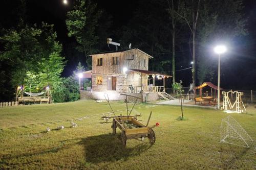 a yard with a wooden house and a playground at night at Doğanın Kalbinde Doğallıkla Buluşma Noktası in Inegol