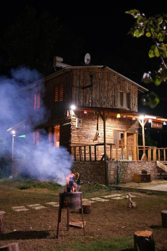 a log house with smoke in front of it at Doğanın Kalbinde Doğallıkla Buluşma Noktası in Inegol