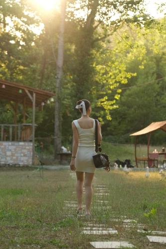 a woman in a dress standing in the grass at Doğanın Kalbinde Doğallıkla Buluşma Noktası in Inegol