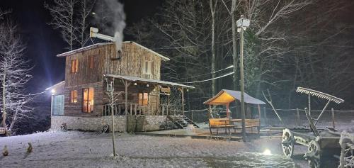 a wooden cabin in the snow at night at Doğanın Kalbinde Doğallıkla Buluşma Noktası in Inegol