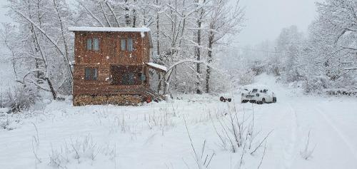 a snow covered yard with a house in the background at Doğanın Kalbinde Doğallıkla Buluşma Noktası in Inegol