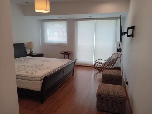 a bedroom with a bed and a chair in it at Luxury Apartment San Isidro in Lima