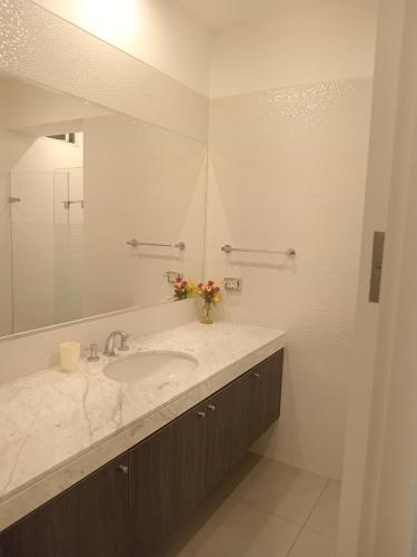 a bathroom with a sink and a mirror at Luxury Apartment San Isidro in Lima