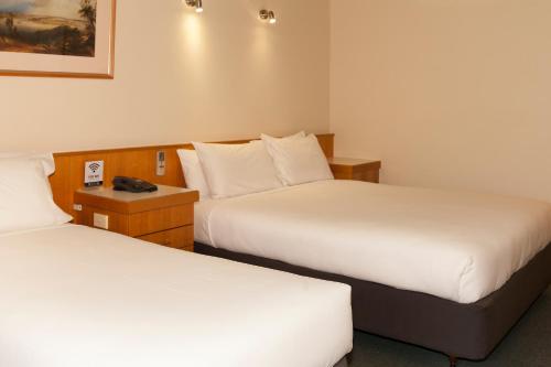 a hotel room with two beds and a telephone at Echuca Nirebo Motel in Echuca