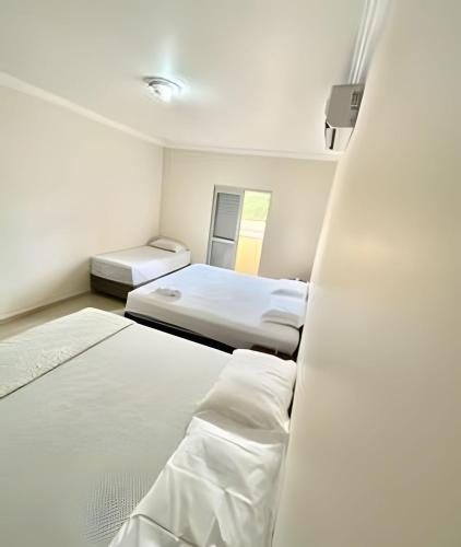 two beds in a small room with two beds at Casa com piscina no Botânico in Ribeirão Preto