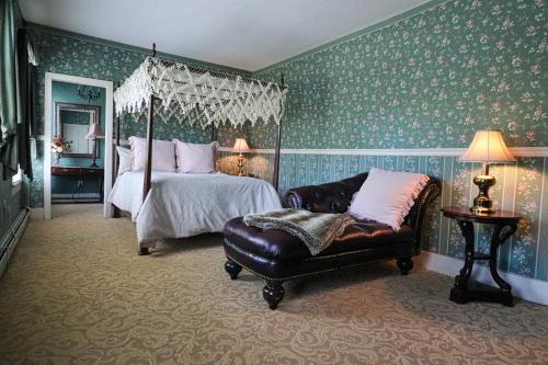 a bedroom with a bed and a couch and a chair at Stroudsmoor Country Inn in Stroudsburg