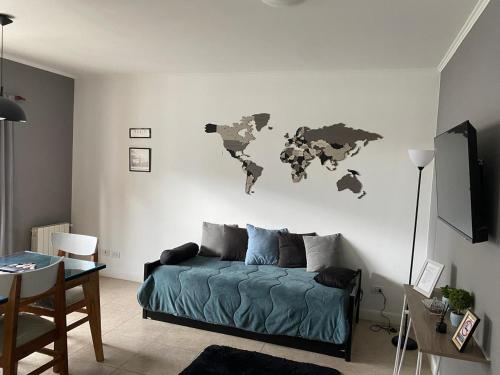 a living room with a bed and a world map on the wall at Altos Patagonia in Río Gallegos