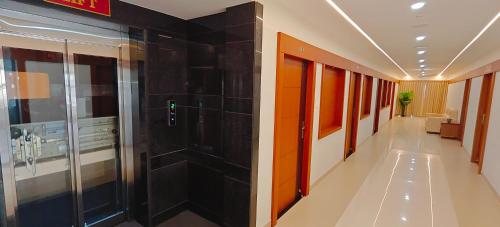 a hallway of a hospital with black tile walls at Aswin Residency in Nāmakkal