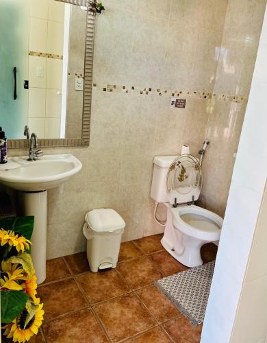 a bathroom with a toilet and a sink at Geribá - casa plana, conforto, adaptada e tudo a pé in Búzios