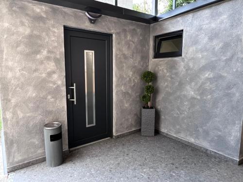 a black door with a potted plant next to it at Moderne City Wohnung Paderborn Zentrum in Paderborn